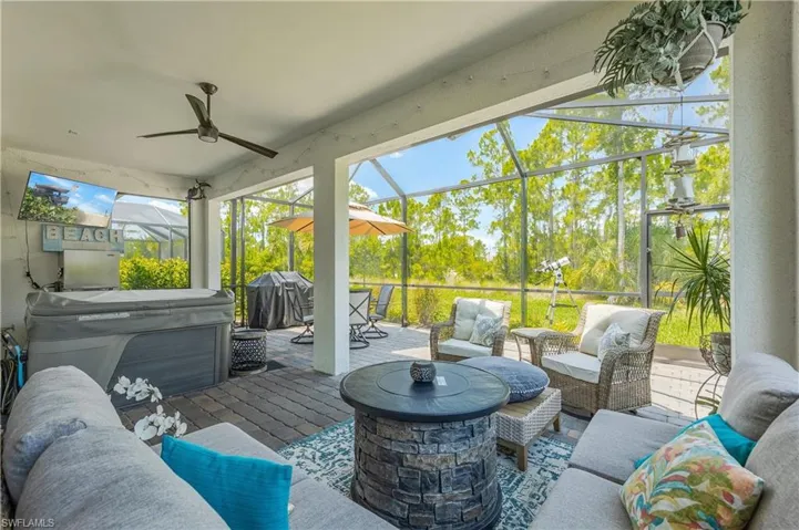 View of patio / terrace featuring a grill, a hot tub, an outdoor living space with a fire pit, and ceiling fan