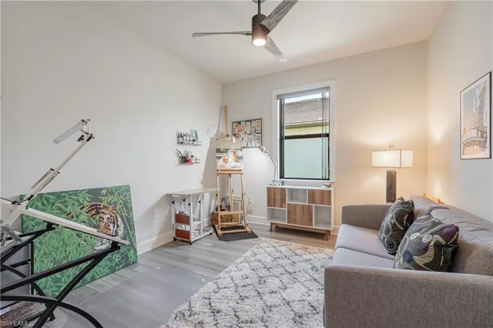 Living room with ceiling fan and hardwood / wood-style floors