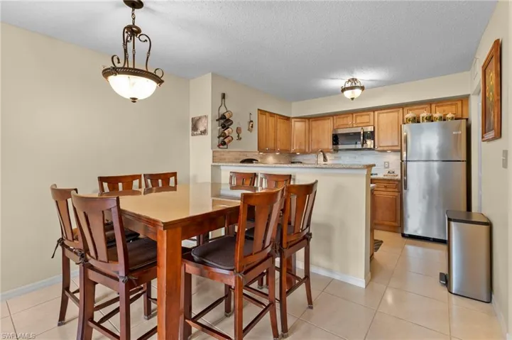 Dining area with a textured ceiling, light tile patterned flooring, and sink