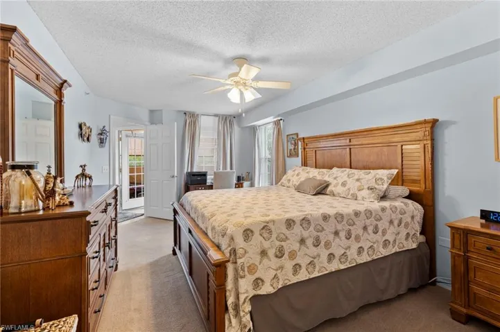 Bedroom featuring light carpet, a textured ceiling, access to exterior, and ceiling fan