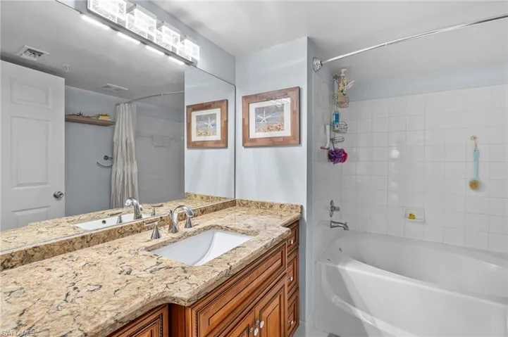 Bathroom with vanity and shower / bath combination with curtain