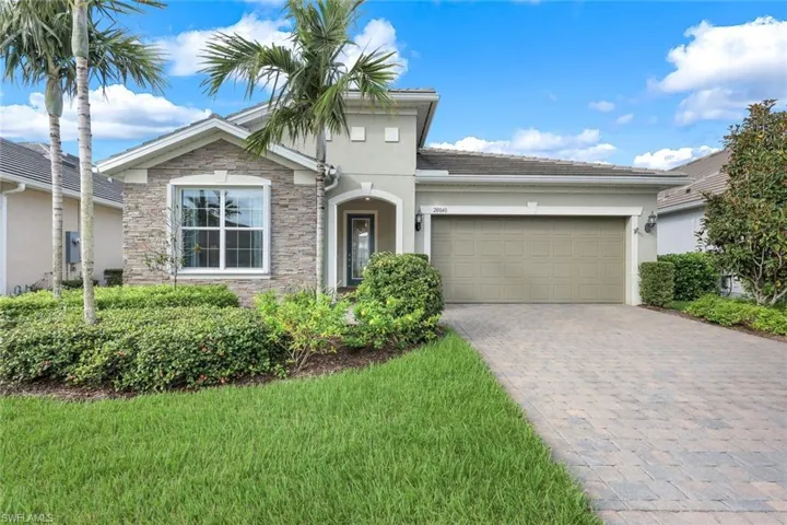 View of front of house featuring a garage and a front lawn