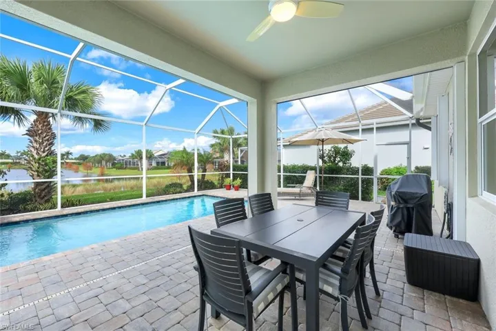View of swimming pool featuring ceiling fan, area for grilling, a lanai, and a patio area