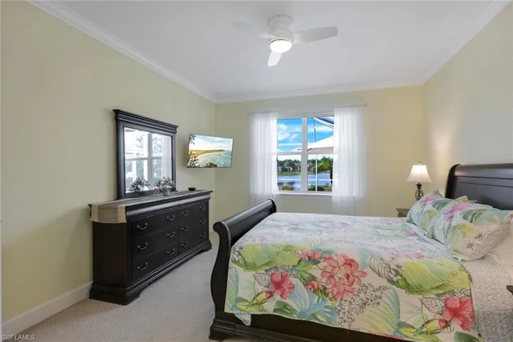 Bedroom with ornamental molding, multiple windows, and ceiling fan