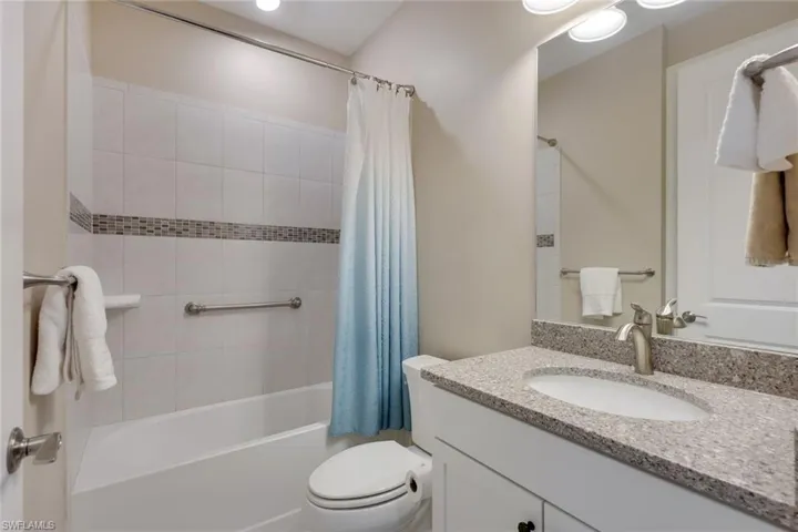 Full bathroom with shower / bathtub combination with curtain, vanity, and toilet