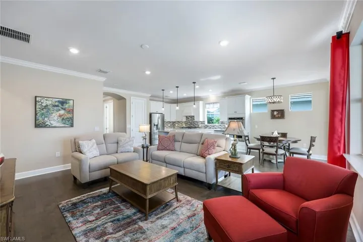 Living room featuring dark wood-type flooring and ornamental molding
