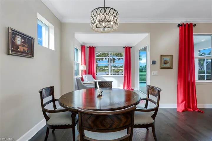 Dining room featuring crown molding, plenty of natural light, an inviting chandelier, and dark hardwood / wood-style floors