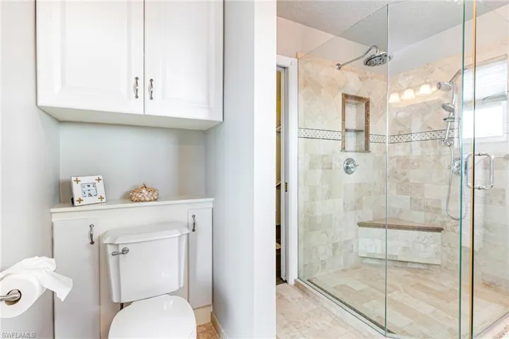 Full bathroom featuring a stall shower and toilet