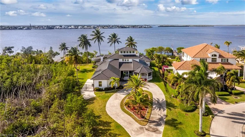 Aerial view of property and surrounding area featuring a nearby body of water