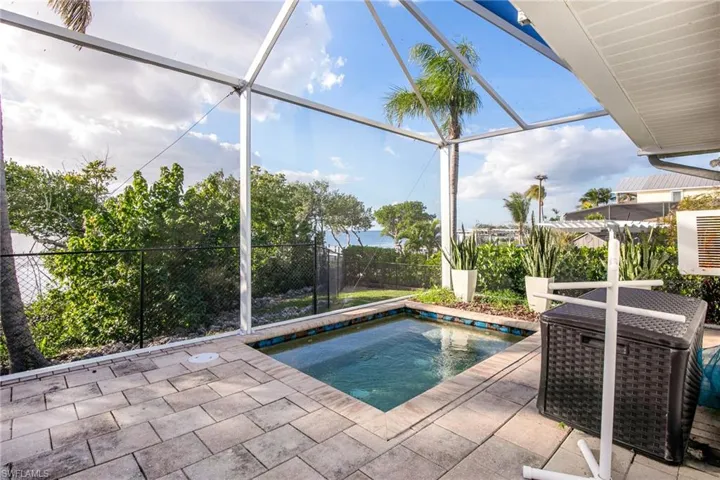 Swimming pool with glass enclosure, a sunroom, and a patio