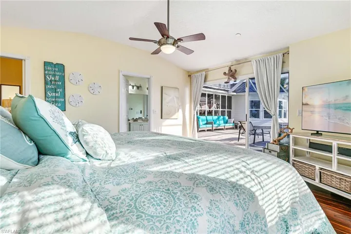 Bedroom with access to exterior, a sunroom, connected bathroom, ceiling fan, and vaulted ceiling