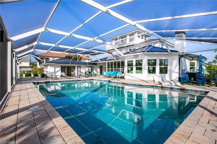 Swimming pool featuring a sunroom, a lanai, and a patio