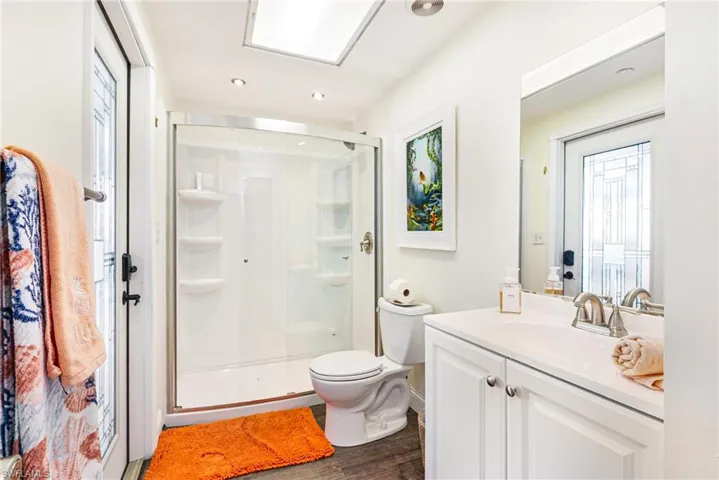 Full bathroom with vanity, a stall shower, dark wood-type flooring, and recessed lighting