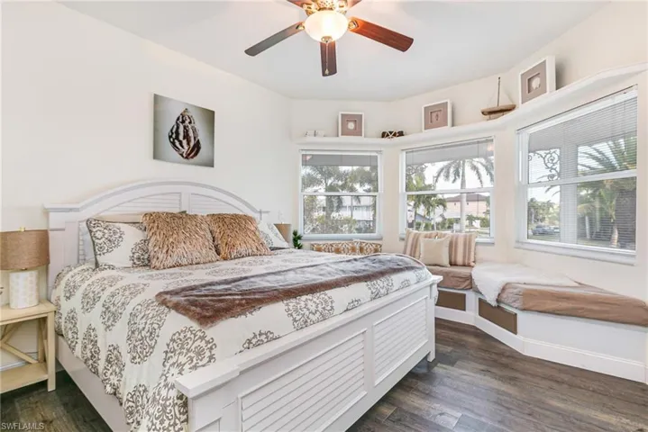 Bedroom with dark wood finished floors and a ceiling fan