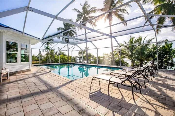 Swimming pool with a sunroom, a patio, and a lanai