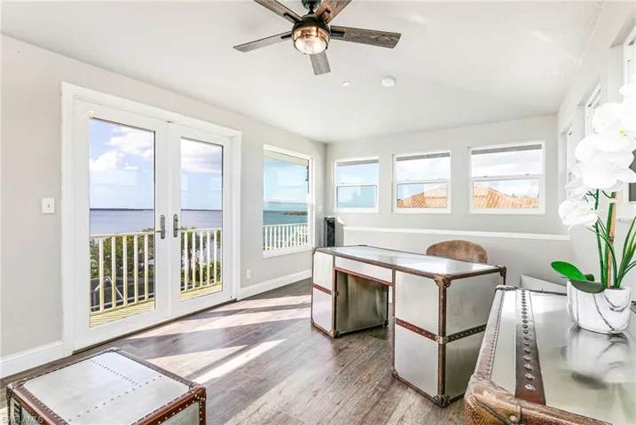 Sunroom featuring french doors, wood finished floors, and a water view