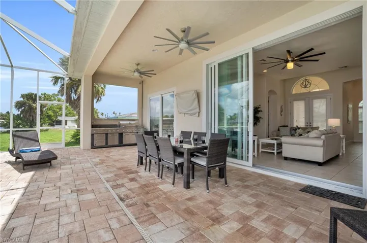 View of patio / terrace with exterior kitchen, glass enclosure, ceiling fan, an outdoor hangout area, and french doors