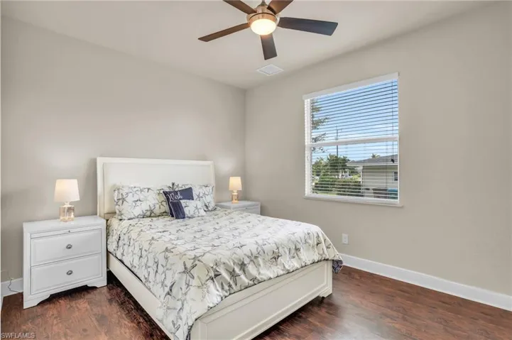 Bedroom with dark hardwood / wood-style floors and ceiling fan