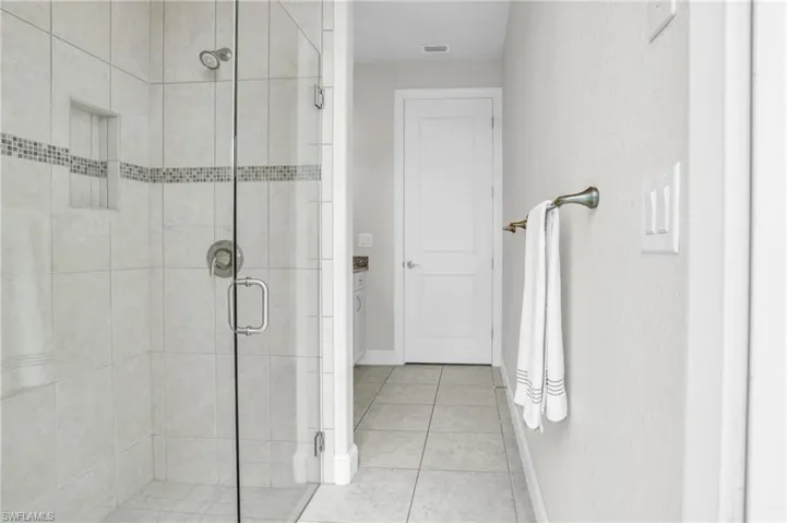 Bathroom with a shower with door, tile flooring, and vanity