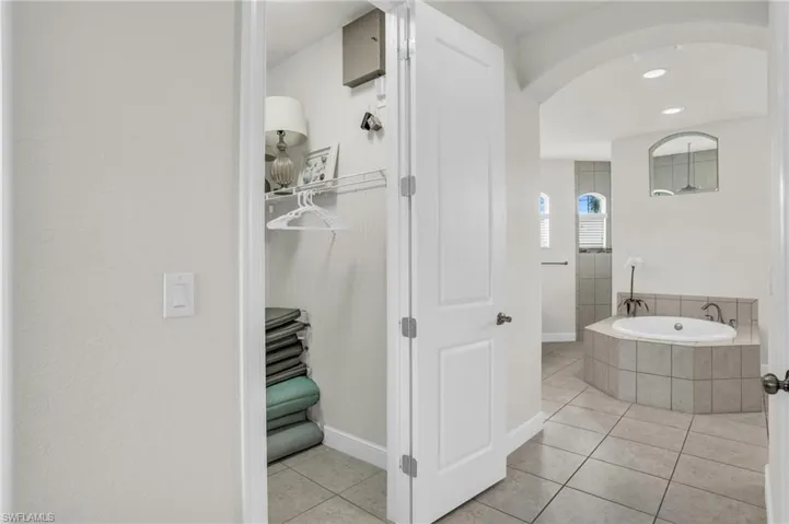 Bathroom featuring a relaxing tiled bath and tile flooring
