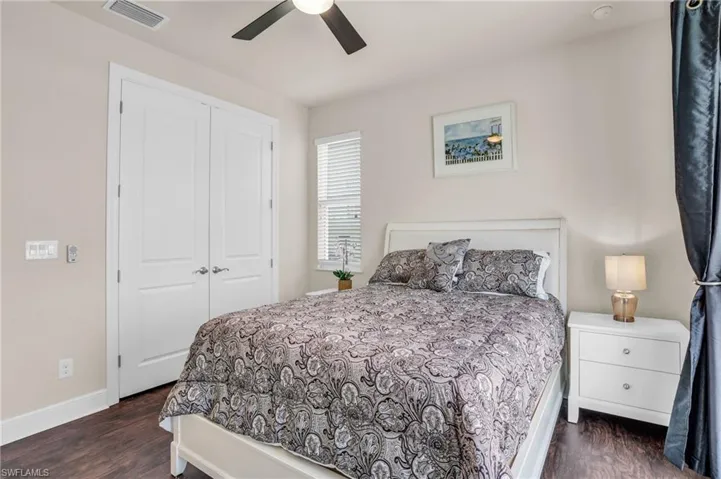 Bedroom with dark wood-type flooring, a closet, and ceiling fan
