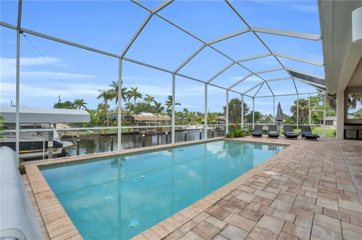 View of swimming pool featuring a patio area, a boat dock, and a lanai