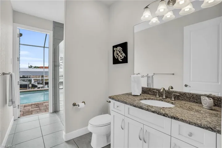 Bathroom featuring tile flooring, toilet, and large vanity