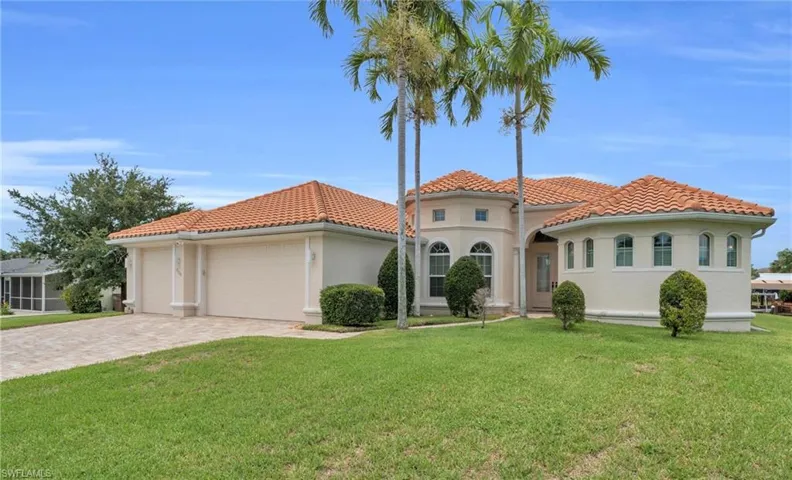Mediterranean / spanish-style home with a front yard and a garage