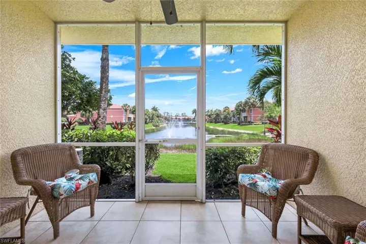 Screened patio featuring a ceiling fan, textured walls, and tile flooring