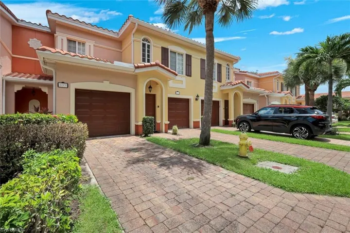 Multi-story townhome featuring a barrel tile roof and stucco exterior