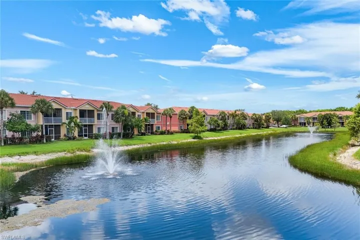 Waterfront property featuring a tranquil pond with a decorative fountain