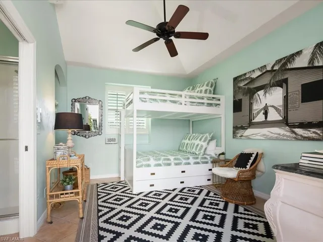 Tiled bedroom with a ceiling fan and arched walkways