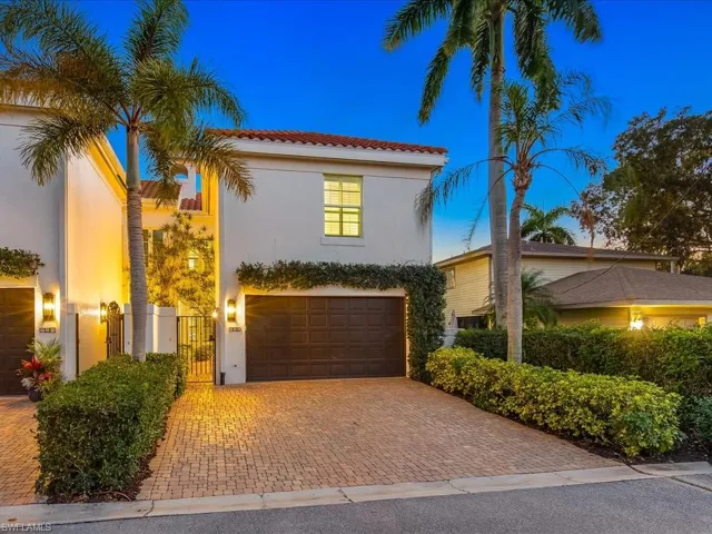 Mediterranean / spanish-style home featuring a garage, decorative driveway, a gate, stucco siding, and a tiled roof