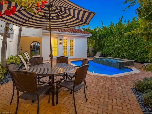 Combined pool / hot tub featuring french doors, outdoor dining space, and a patio area