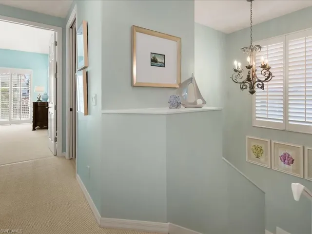 Hallway featuring suspended lighting and carpet flooring