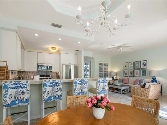 Dining area featuring ceiling fan, suspended lighting, a tray ceiling, and crown molding