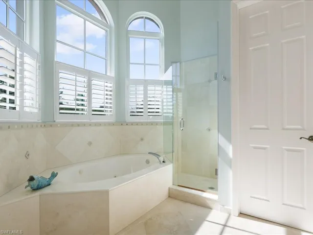Full bath featuring a stall shower, a bath, and light tile patterned floors