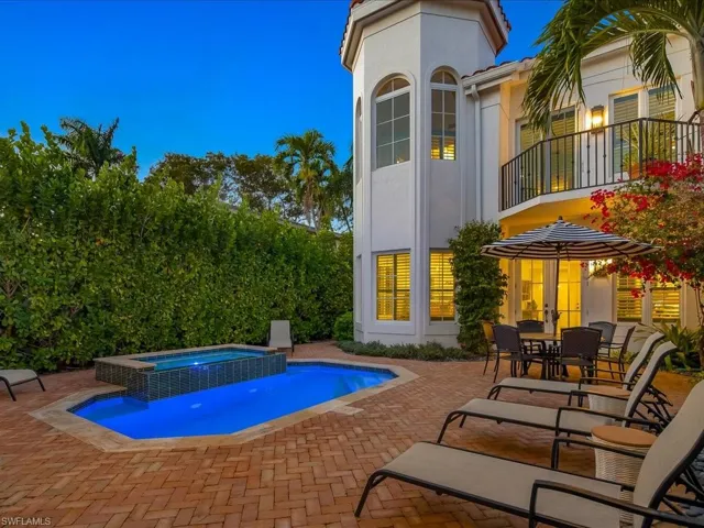 Integrated pool / spa with a patio area, outdoor dining area, and a balcony