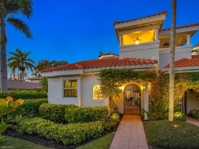 Doorway to property with a tiled roof, a gate, and stucco siding