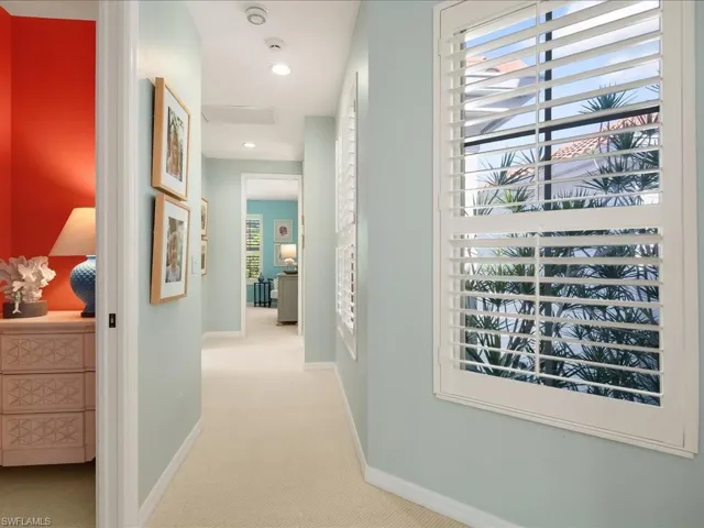 Hall with light colored carpet and recessed lighting