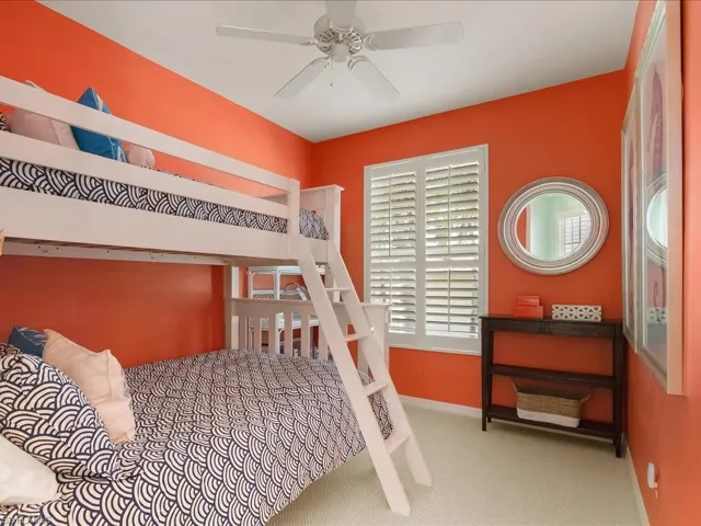 Carpeted bedroom featuring a ceiling fan and baseboards