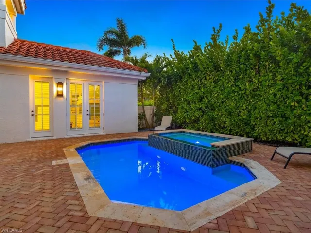 Integrated pool / hot tub featuring a patio and french doors