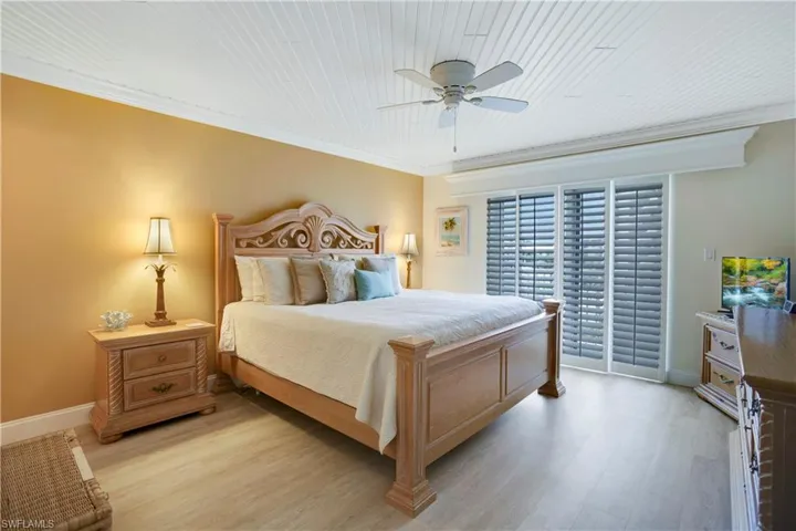 Primary suite with custom wood plank ceiling and plantation shutters out to open back balcony!