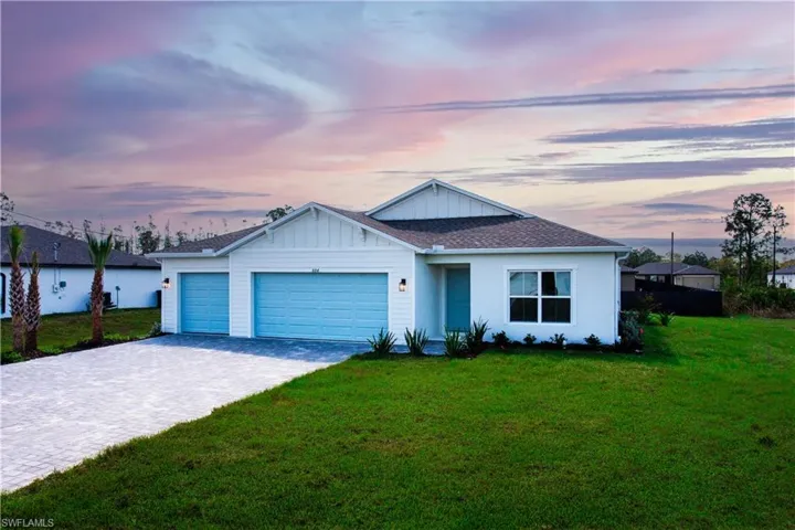 Single story home with decorative driveway, a front lawn, an attached garage, and a shingled roof