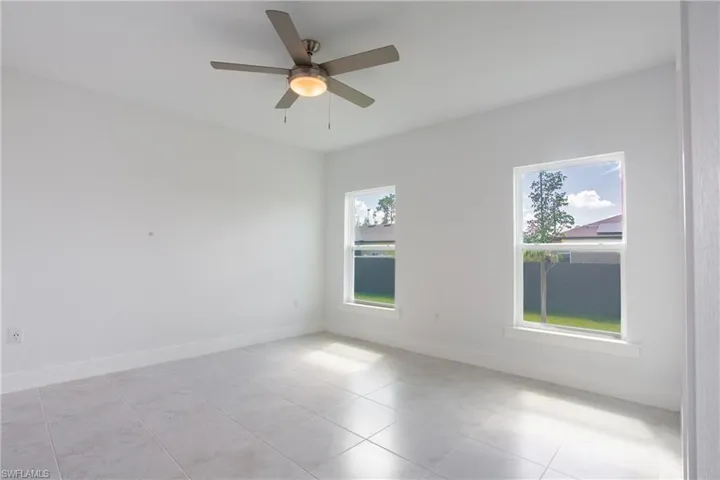 Spare room with baseboards and a ceiling fan