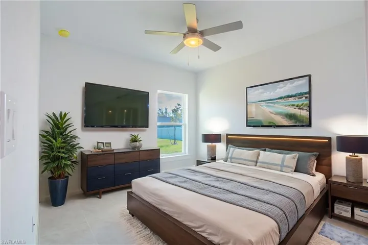 Bedroom with light tile patterned floors and a ceiling fan