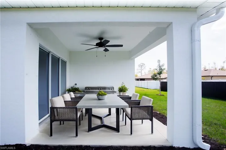 View of patio / terrace with outdoor dining area, ceiling fan, and fence