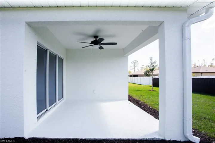 View of patio with a ceiling fan and fence