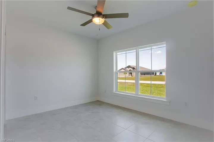 Empty room with ceiling fan and baseboards
