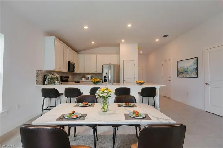Dining area featuring visible vents, recessed lighting, and lofted ceiling
